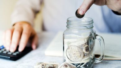 hand-putting-coin-inside-jar
